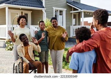 Portrait of African American family waving to guests after Summer party