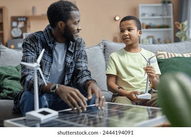 Portrait of African American father teaching son on renewable energy sources and solar panels - Powered by Shutterstock