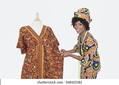 Portrait of an African American female fashion designer working on dashiki over gray background