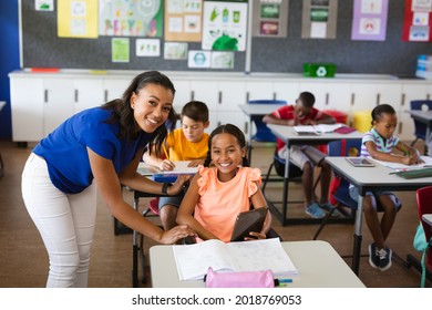 Portrait of african american female teacher and disabled girl smiling in class at elementary school. school and education concept - Powered by Shutterstock