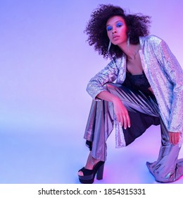 Portrait Of An African American Girl In Neon Light.  Dressed In A Sequin Suit And Posing In Fashionable Poses.  Retro Wave 1980s.  Advertising Poster.Copyspace.