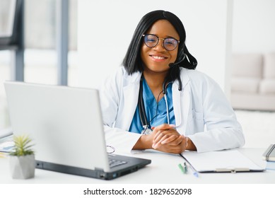 Portrait of african american happy smiling young doctor in headset consulting patient over the phone. Health care call center online concept - Powered by Shutterstock