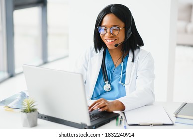 Portrait of african american happy smiling young doctor in headset consulting patient over the phone. Health care call center online concept