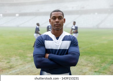 Portrait of African American male rugby player standing with arms crossed in stadium - Powered by Shutterstock