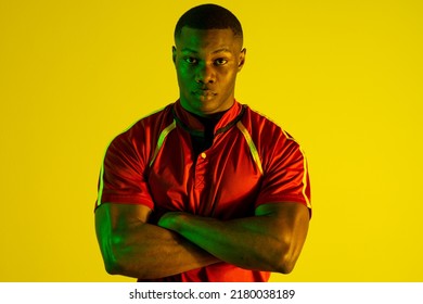 Portrait of african american male rugby player over yellow lighting. Sport, movement, training and active lifestyle concept. - Powered by Shutterstock