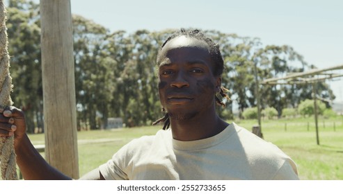 Portrait of african american male soldier with dreadlocks holding rope on army obstacle course. healthy active lifestyle, cross training outdoors at boot camp. - Powered by Shutterstock