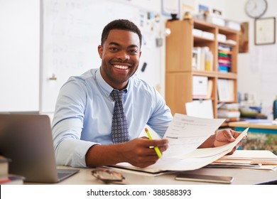 Portrait of African American male teacher working at desk