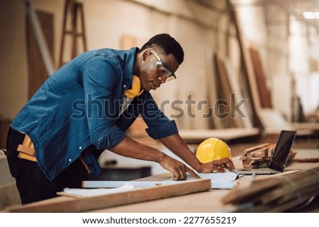 Portrait african american man carpenter craftman working in wood factory, small business wood workshop. Timber industry and furniture factory.