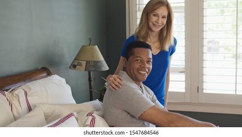 Portrait Of African American Man And Caucasian Woman Senior Couple In Bedroom Smiling At Camera. Happy Husband And Wife At Home Getting Ready For The Day