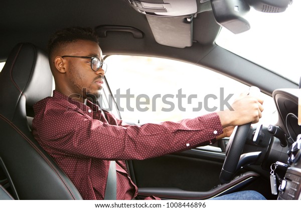 Portrait of african\
american man driving\
car