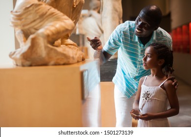 Portrait Of African American Man And His Daughter At Hall Of Art Museum Among Exhibits Of Antiquity