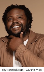 portrait of african american man in his 30s smiling confidently and posing with hand on chin on neutral background Stock Photo