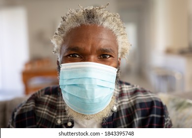 Portrait of African American man at home, wearing a mask and looking to camera. Social distancing and self isolating at home during Coronavirus Covid 19 quarantine lockdown. - Powered by Shutterstock