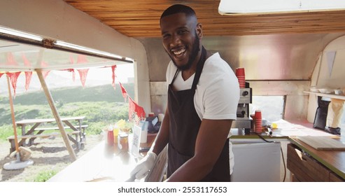 Portrait of african american man smiling while preparing hot dogs in the food truck. food truck and street food concept - Powered by Shutterstock