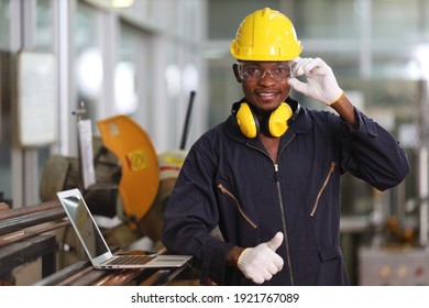 Portrait Of African American Mechanic Engineer Worker Wearing Safety Equipment Beside The Sawing Machine In Manufacturing Factory