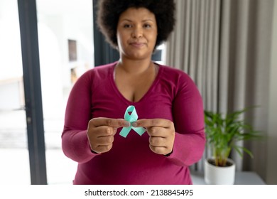 Portrait of african american mid adult woman showing prostate cancer awareness blue ribbon. unaltered, cancer, healthcare and medicine and social awareness symbol concept. - Powered by Shutterstock