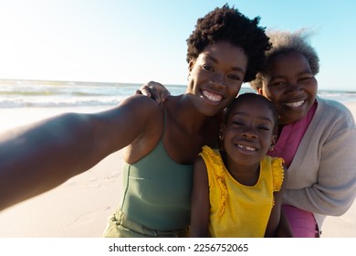 Portrait of african american multi-generation family enjoying at beach against sea and sky in summer. Copy space, unaltered, childhood, retirement, together, mother, daughter, summer, nature, smiling. - Powered by Shutterstock