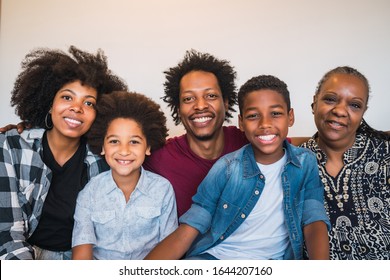 Portrait Of African American Multigenerational Family Looking At Camera While Sitting On Sofa Couch At Home. Family And Lifestyle Concept.