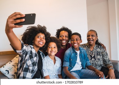 Portrait Of African American Multigenerational Family Taking A Selfie Together With Mobile Phone At Home. Family And Lifestyle Concept.