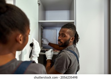 Portrait Of African American Professional Electrician Sharing His Knowledge About Specific Of Fuse Box Installation Looking At Female African American Assistant. Diverse Couple Working Together.