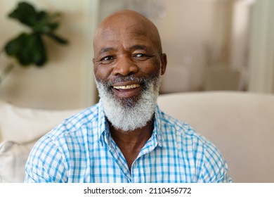 Portrait of african american senior man smiling while sitting on the couch at home. people and emotions concept, unaltered.