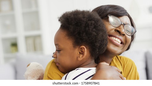 Portrait Of African American Woman Hugging His Cute Little Daughter. Little Girl Greeting Her Mother At Home. Happy Mother's Day. 