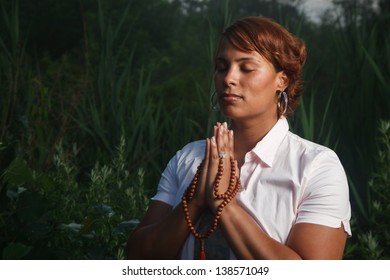 Portrait Of African American Woman Praying Outdoors At Night.