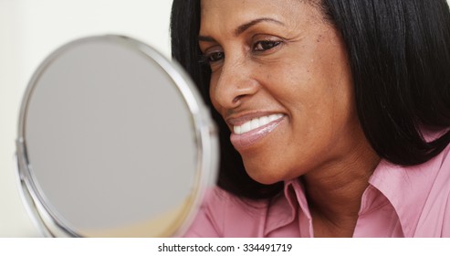 Portrait Of African American Woman Smiling At A Mirror