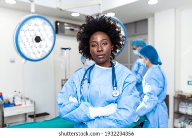 Portrait Of African American Woman Surgeon Standing In Operating Room, Ready To Work On A Patient. Female Medical Worker In Surgical Uniform In Operation Theater.