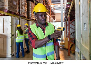 Portrait Of African Black Warehouse Worker Hold Hand Scanner To Do Inventory Work Stock In Distribution Warehouse. Traceability FIFO LIFO Inventory Just In Time And Warehouse Concept Photo.