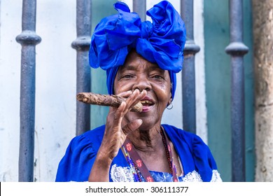 Portrait Of African Cuban Woman Smoking Cigar In Havana, Cuba