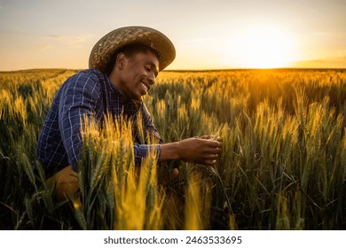 Portrait of african farmer in his growing wheat field. He is satisfied with progress of plants. - Powered by Shutterstock