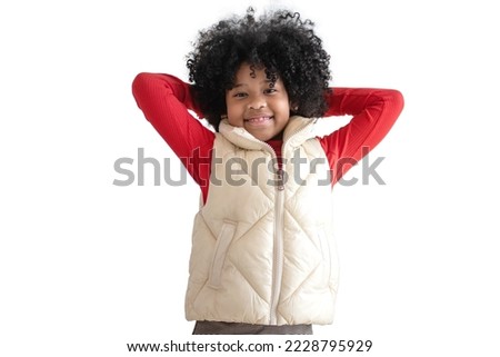 Portrait of African little girl in warm outerwear cream vest and sweater shirt, put her hands to join the back of the neck, children's fashion clothing and fashion isolated on white