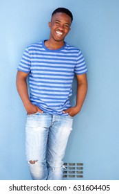 Portrait Of African Male Youth Smiling Against Blue Wall