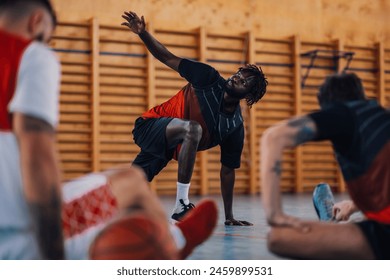 Portrait of an african man professional basketball team member stretching and warming up before training in a sports hall. Health, wellness and game start. Black male player preparing for a match. - Powered by Shutterstock