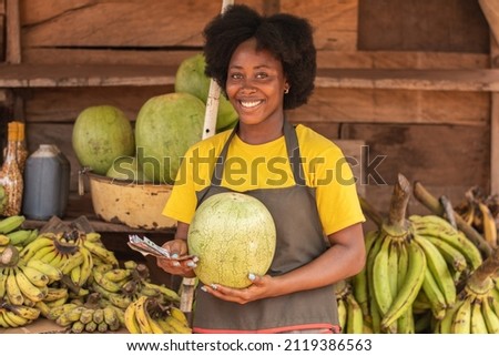 portrait of an african market woman holding a watermelon
