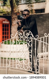 Portrait Of African Model Smoking Cigar And Posing For Photography.