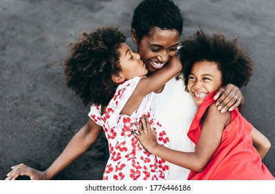 Portrait Of African Mother With Twins Sisters Outdoor - Black Family Having Fun On The Beach Playing Together - Love, Real People And Vacation Concept - Main Focus On Mum Face