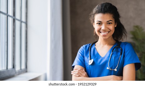 Portrait of african-american female doctor with stethoscope on hospital background. A physician standing with cheerful gesture. Woman nurse wearing doctor uniform with smiling face. Health insurance  - Powered by Shutterstock