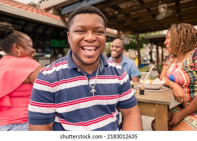 Portrait Of An African-American Man Hanging Out With His Family Or Friends At A Beach Restaurant.