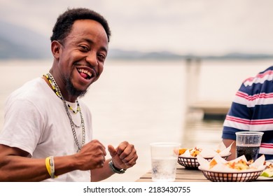 Portrait Of An African-American Man Hanging Out With His Family Or Friends At A Beach Restaurant.