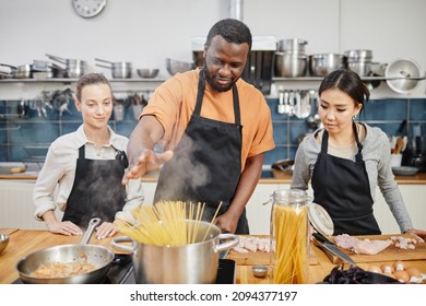 Portrait of African-American man making pasta during cooking class in kitchen interior - Powered by Shutterstock