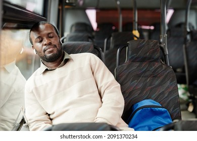 Portrait of African-American man sleeping on bus while traveling by public transport in city, copy space - Powered by Shutterstock