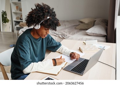 Portrait Of African-American Teenage Boy Studying At Home Or In College Dorm And Using Laptop, Copy Space