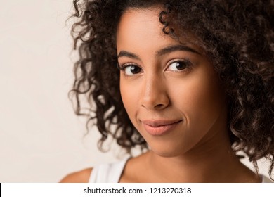 Portrait Of African-american Woman With Curly Hair Against Light Background