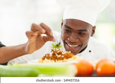 retrato del chef afroamericano en la cocina del restaurante hornear plato de pasta