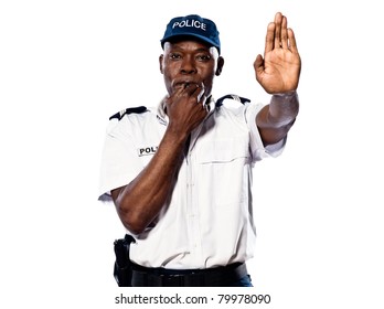 Portrait of an Afro American police officer holding a hand up to motion "stop" while blowing whistle on white background - Powered by Shutterstock
