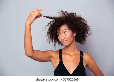 Portrait Of Afro American Woman Touching Her Hair Over Gray Background