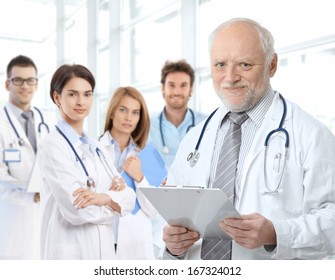 Portrait Of Aged Male Doctor Teaching Medical Students.