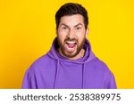 Portrait of aggressive angry mad unhappy man with bristle dressed purple hoodie loudly screaming isolated on yellow color background